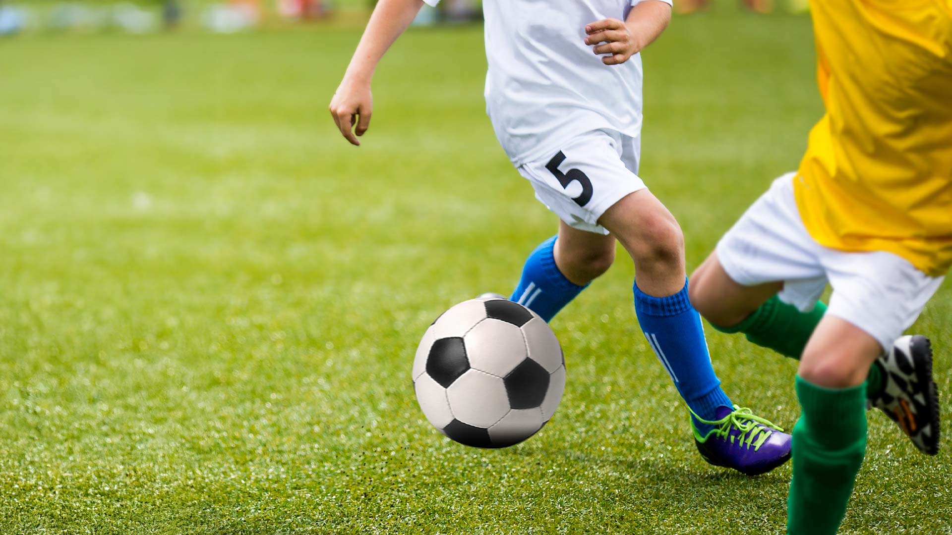 Kinder spielen Fußball, Jugendmannschaft, zwei SpielerInnen spielen um einen Ball